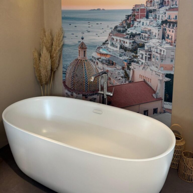 Badewanne mit Bild als Hintergrund an der Wand und verschiedenen Designelementen
