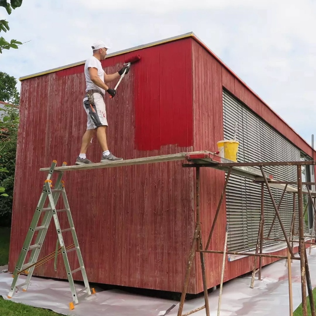 Container gestrichen in rot mit Sergej Gestel auf einem Gerüst